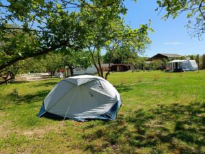 Tent op de camping in de boomgaard zodat er zon en schaduw is